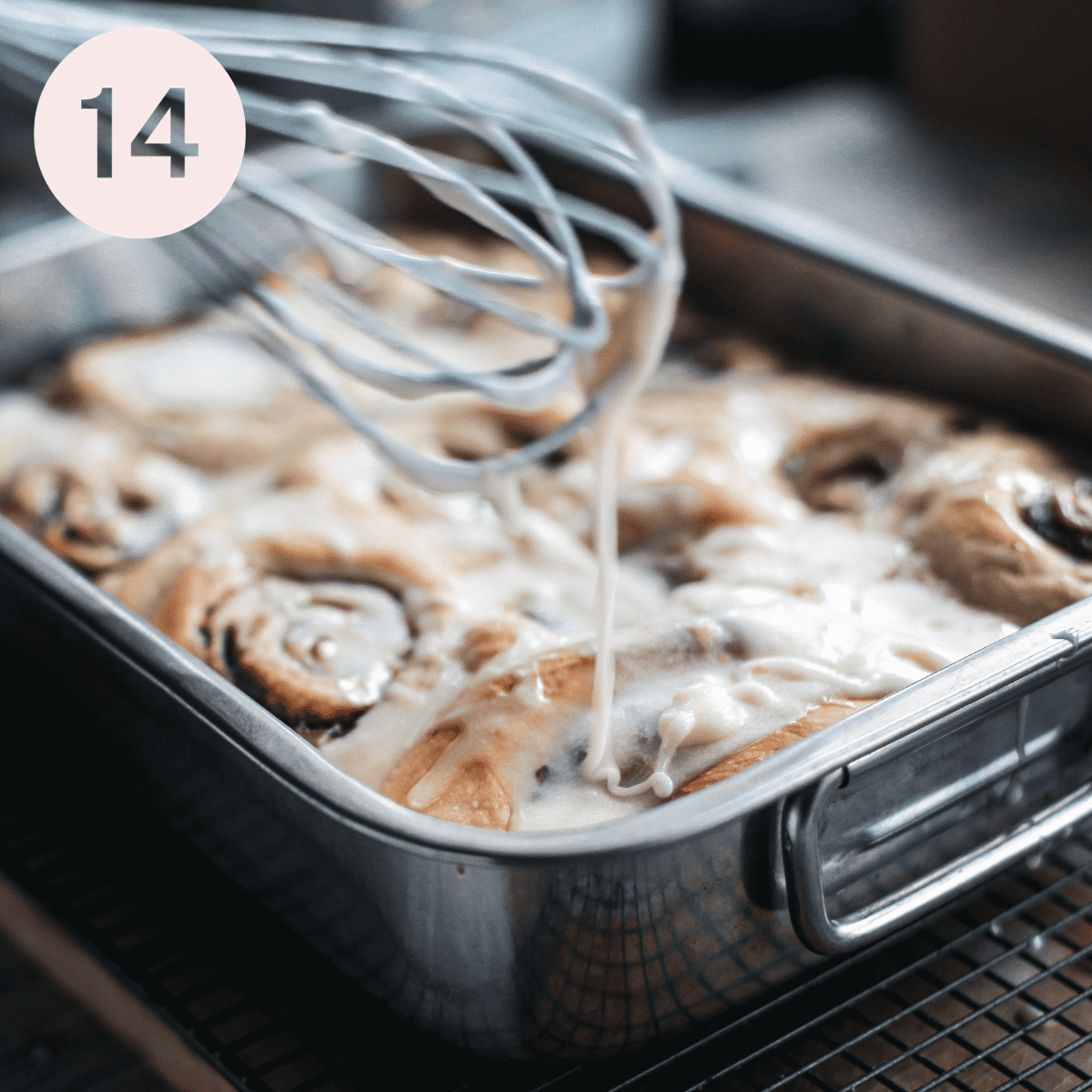 Drizzling icing on cooked cinnamon rolls.